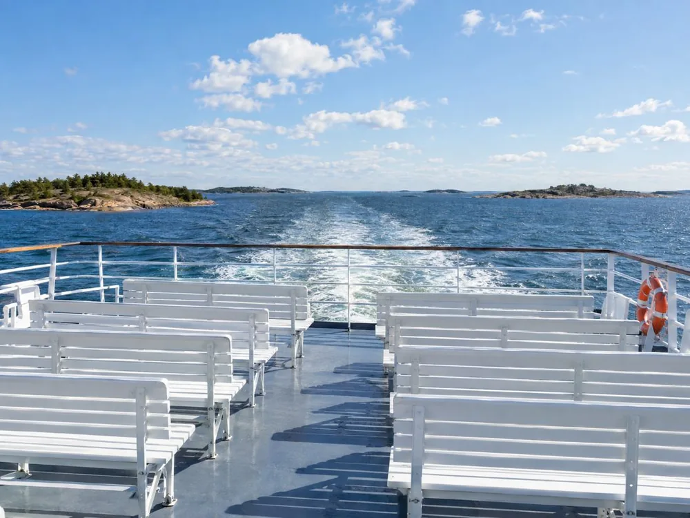 Passagiere auf dem offenen Sonnendeck eines Helsinki-Schären-Sightseeing-Boots